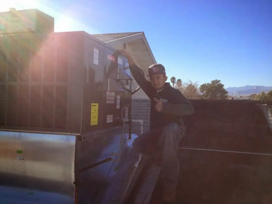 HVAC technician performing AC Tune-Up on a rooftop unit in Telford